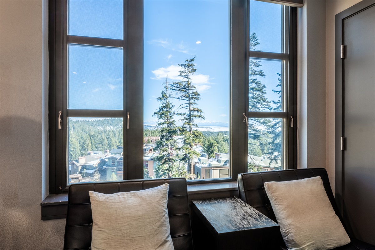 Black leather lounge chairs sit beneath the window, creating a perfect perch for coffee, conversation, or taking in the Village views.