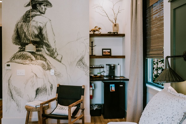In-suite coffee bar at Rancher's Rest &mdash; Keurig, K-cups, and a mini fridge in a curated modern Western nook. A beverage station for short stays; no kitchen.