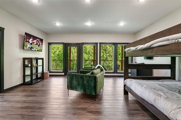Spacious bunk and game room with balcony access and TV.
