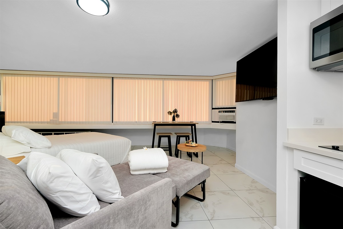 Bright, modern, and inviting — this stylish studio features a plush sleeper sofa, sleek kitchenette, and a dining nook framed by floor-to-ceiling windows. Enjoy sunset hues over the marina from the comfort of your island retreat.