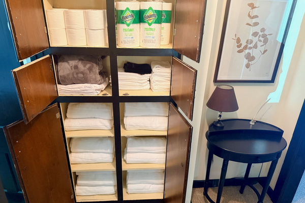 Built-in storage stocked with fresh linens and extra bedding.