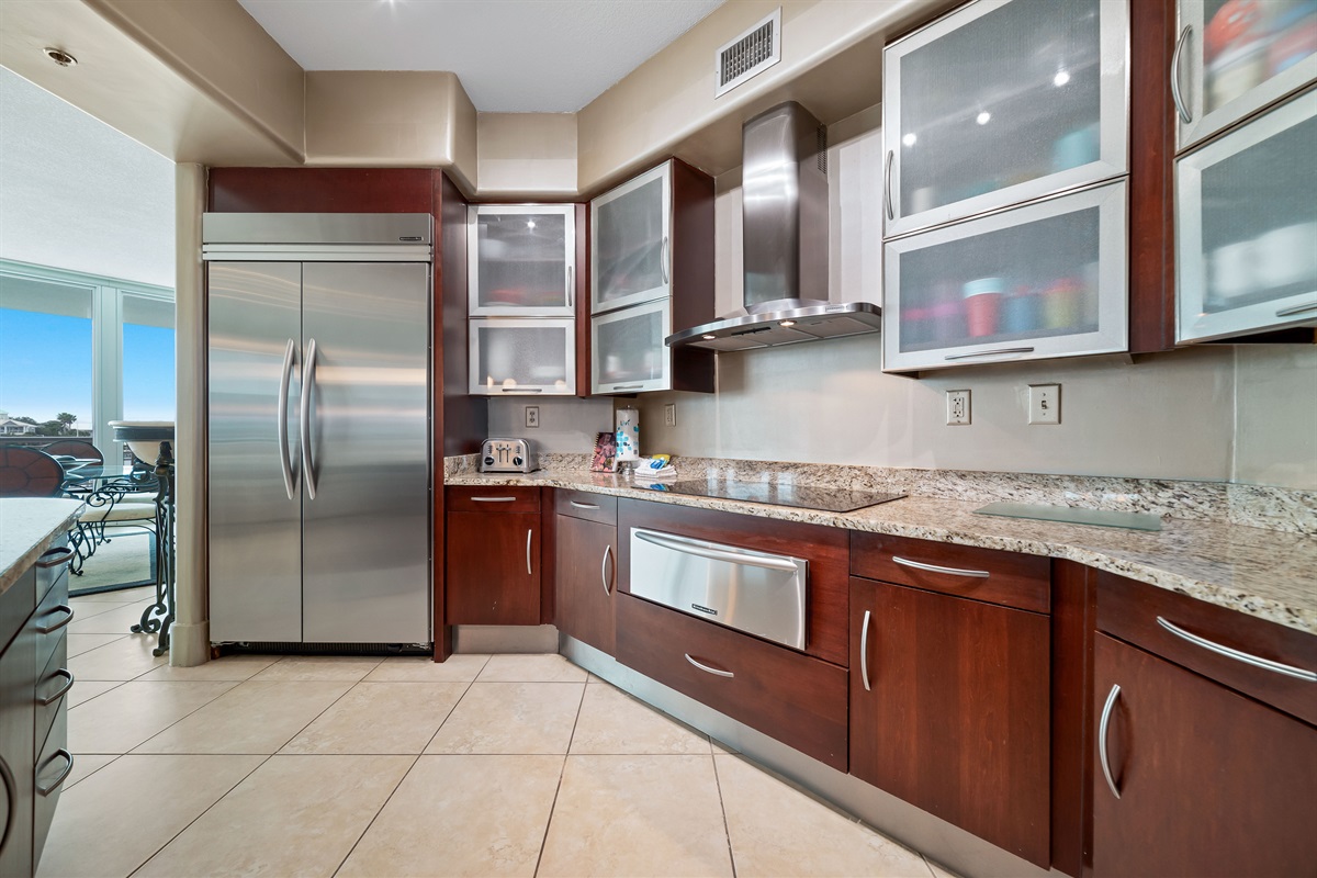 This gourmet kitchen, featuring stainless steel appliances and granite countertops, seamlessly flows into the spacious living area, perfect for entertaining and enjoying breathtaking views.