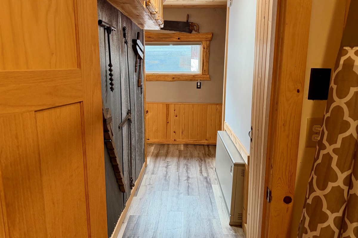 Heading back down the hall, you’ll find the staircase on the right leading up to the two upstairs bedrooms. Along the way, enjoy charming rustic antiques and cabin touches that add warmth and character with North Shore vibes.