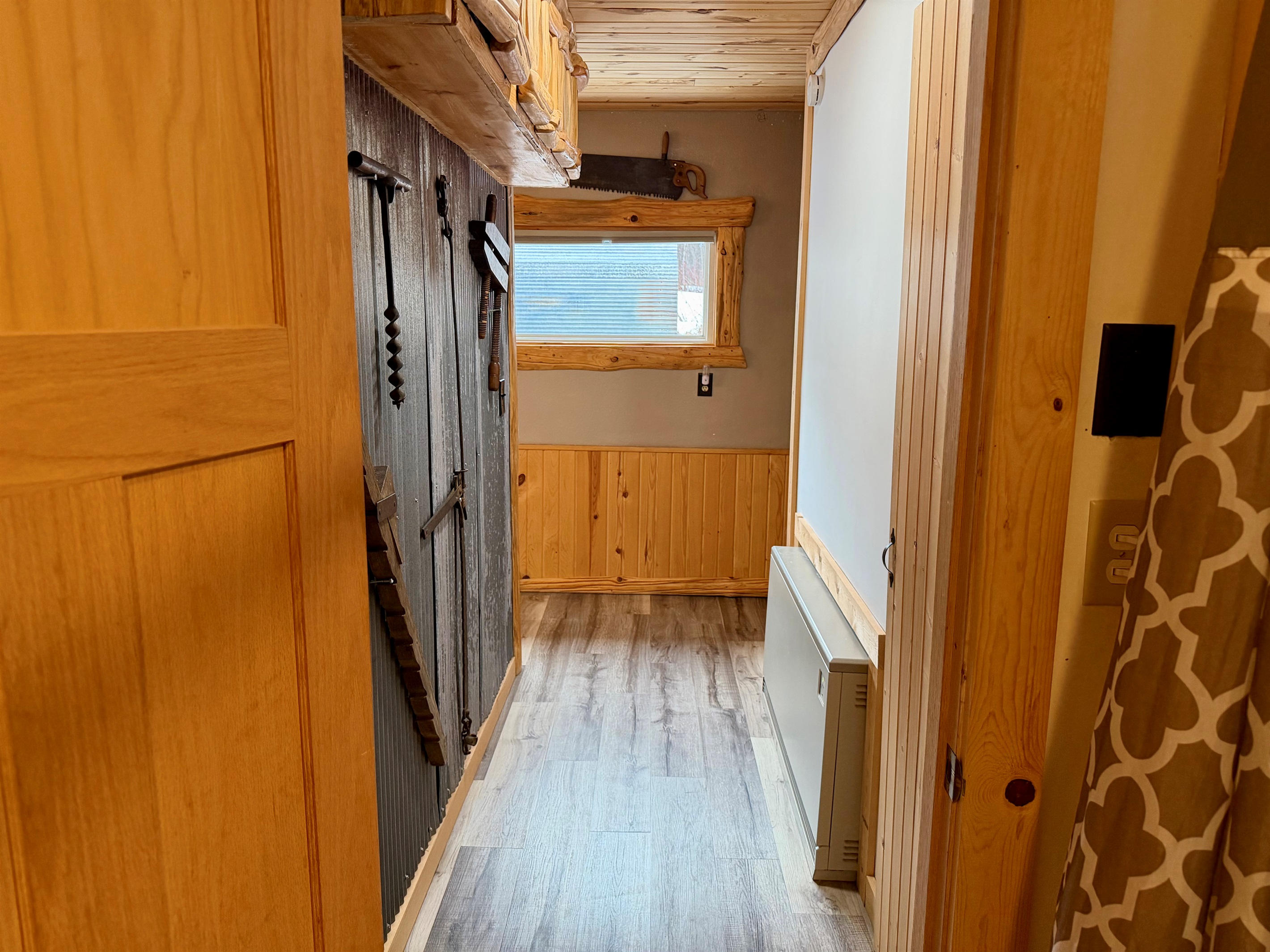 Heading back down the hall, you’ll find the staircase on the right leading up to the two upstairs bedrooms. Along the way, enjoy charming rustic antiques and cabin touches that add warmth and character with North Shore vibes.