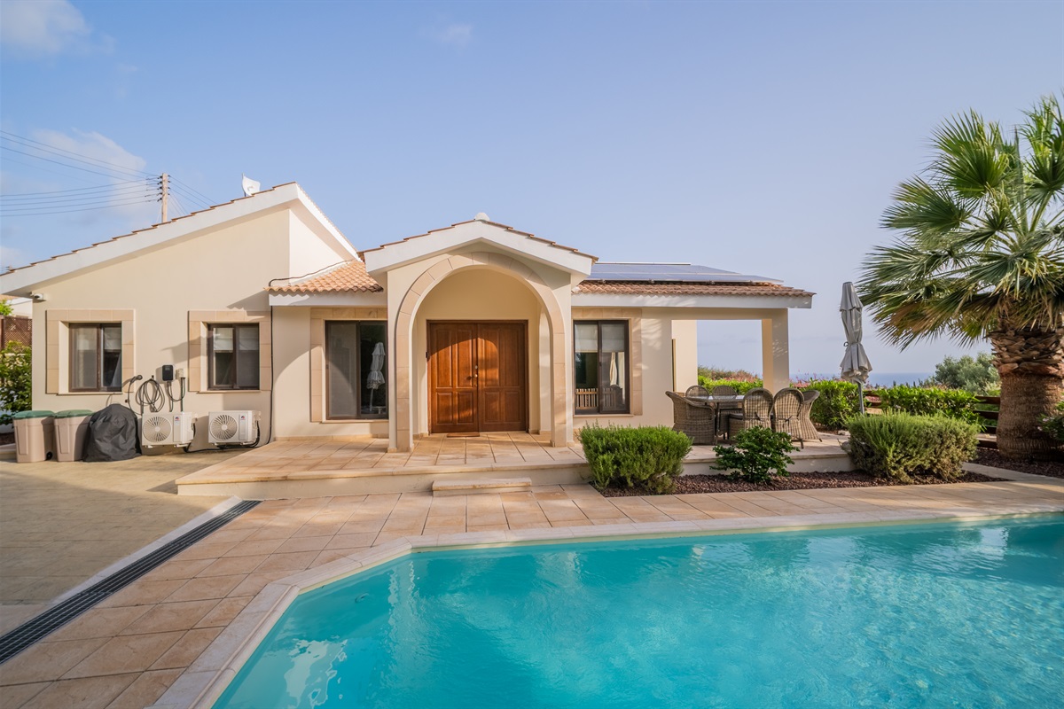 Luxurious 3-bedroom villa with a bungalow layout, featuring a large swimming pool, an outdoor hot tub, well-kept garden with mature trees, and stunning views of the Mediterranean and the Troodos foothills.