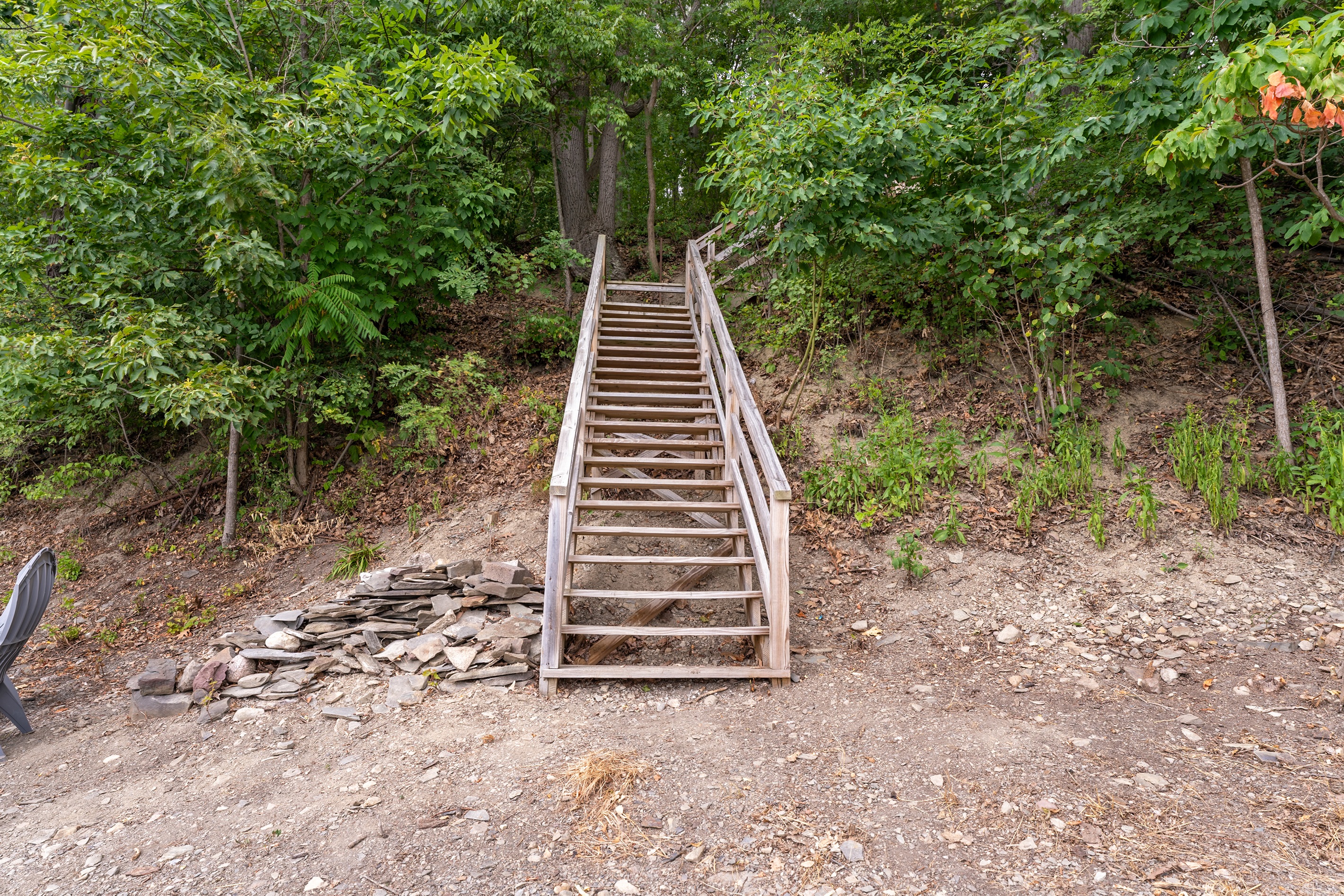 Convenient wooden staircase offers easy access from the home down to your private lakeside escape.