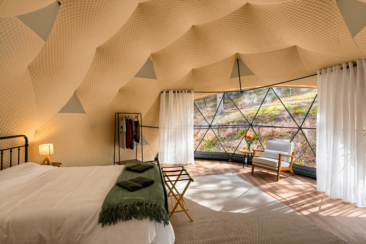 A welcoming queen bed awaits inside your Ozark glamping dome.