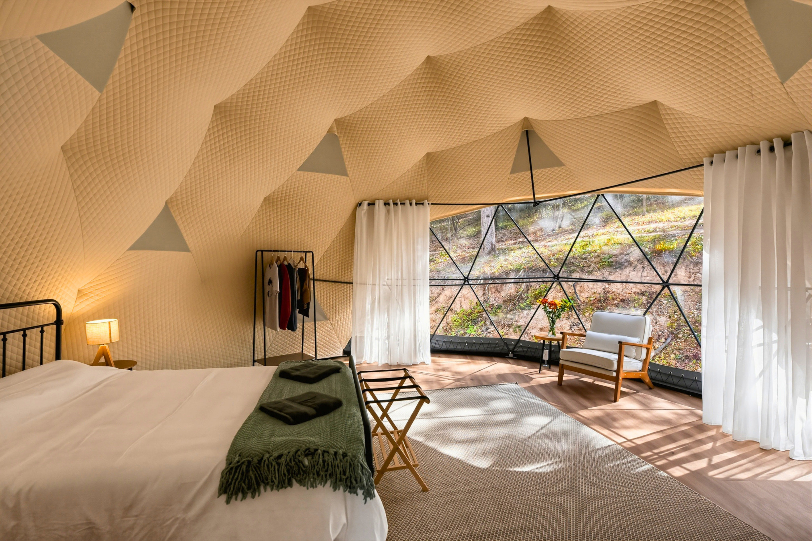 A welcoming queen bed awaits inside your Ozark glamping dome.