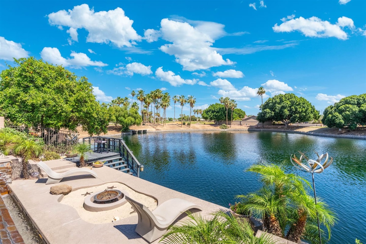 Step out to your private lakefront terrace and take it all in — panoramic water views, swaying palms, and a built-in fire pit perfect for gathering as the day winds down.