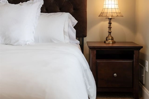 Stylish bedside table with a lamp, providing both convenience and ambiance for your nighttime reading or relaxation.