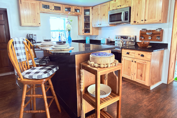 Kitchen view featuring our spacious granite island, garden window, and extensive spice collection. A bright, functional space perfect for preparing meals during your stay. 
