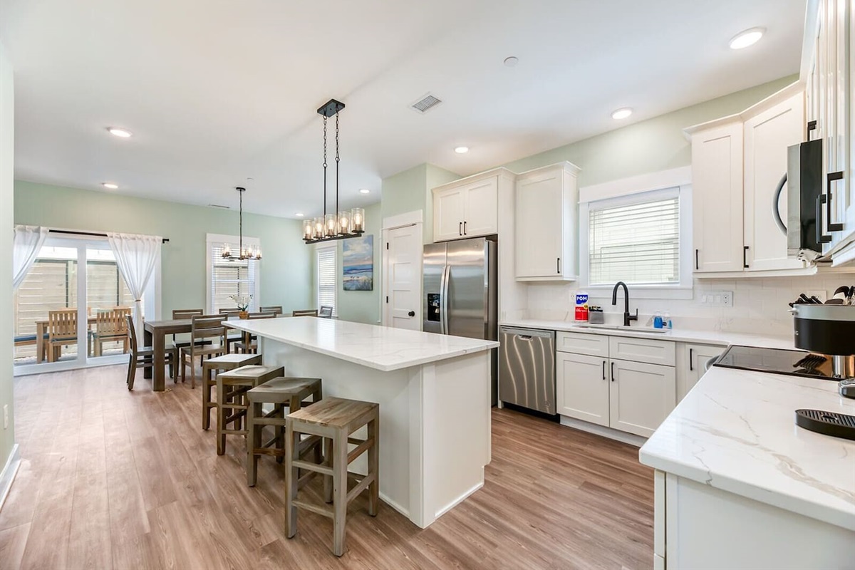 Fully stocked kitchen with modern appliances, ample counter space, and a large island perfect for meals and conversation.