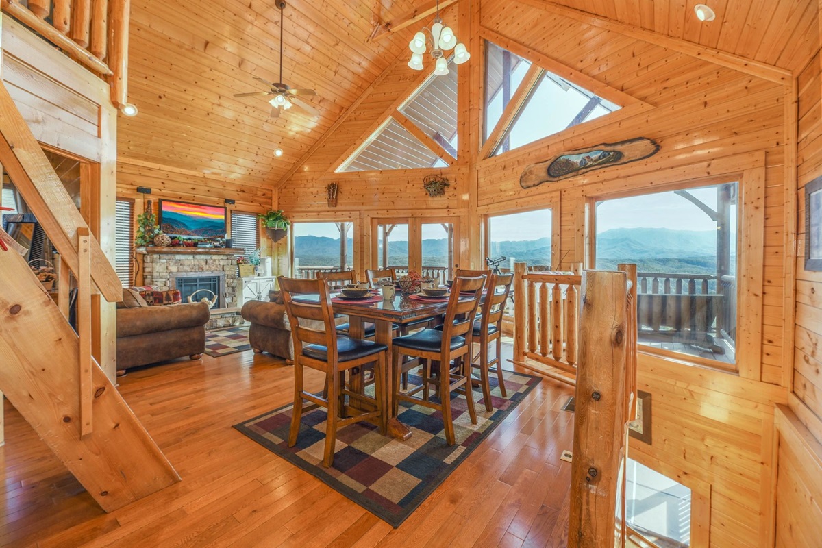 - Bright open-concept cabin with vaulted ceilings and floor-to-ceiling mountain views   - Gather around the dining table surrounded by warm wood finishes and natural light   - Perfect blend of rustic charm and cozy Smoky Mountain ambiance for family meals