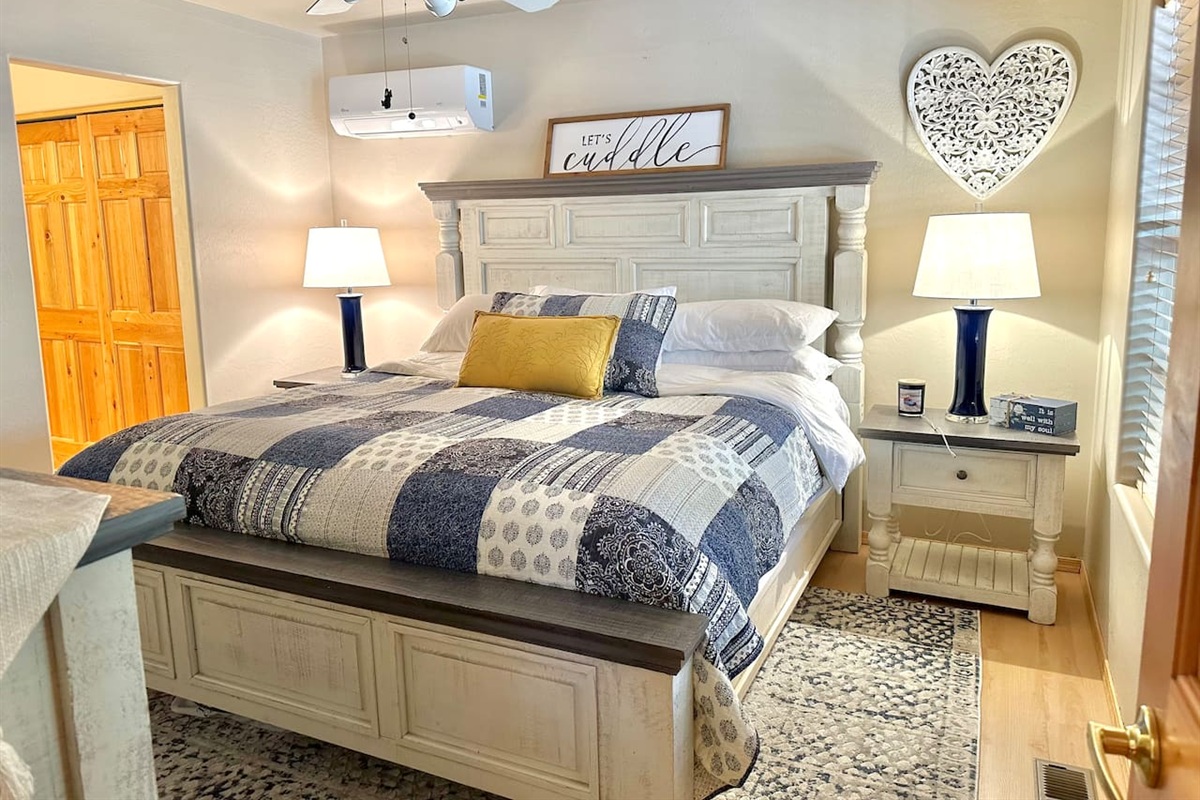 Master bedroom with King bed, mini-split, bed side tables and lamps, and plenty of storage space