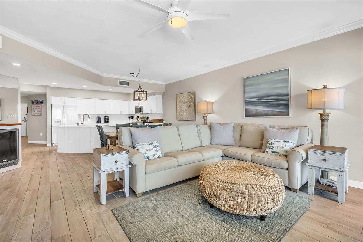 This well-appointed living space offers a comfortable sectional sofa, a round coffee table, and a dining area with seating for six, creating a welcoming atmosphere.