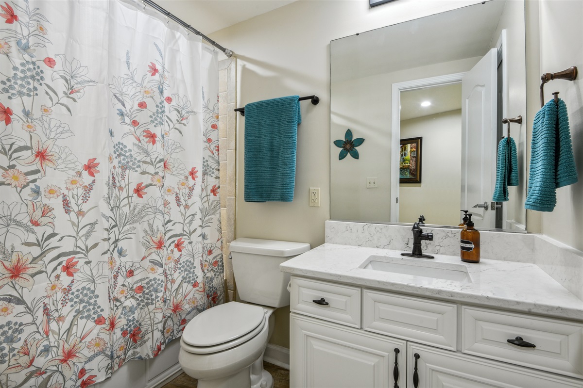 Hall bathroom with door to twin room. Tub and shower combination.