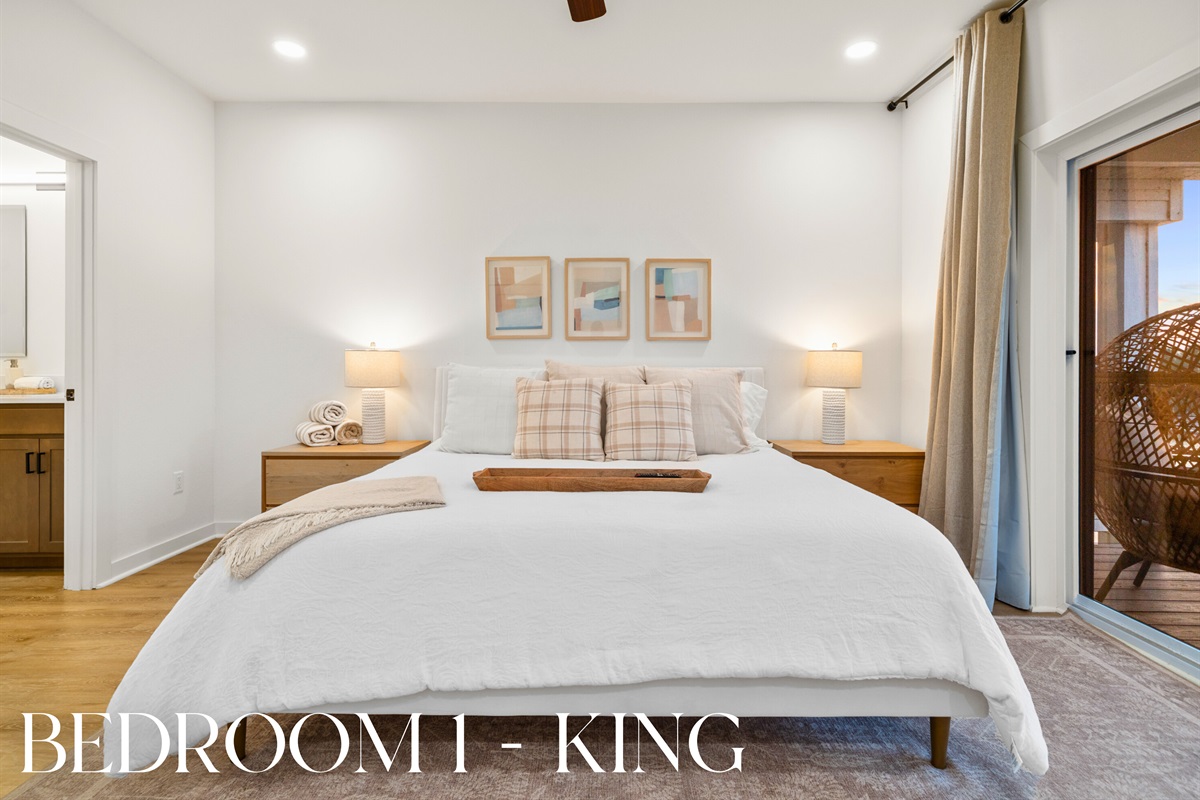 Primary bedroom with king bed and soft neutral d&eacute;cor.