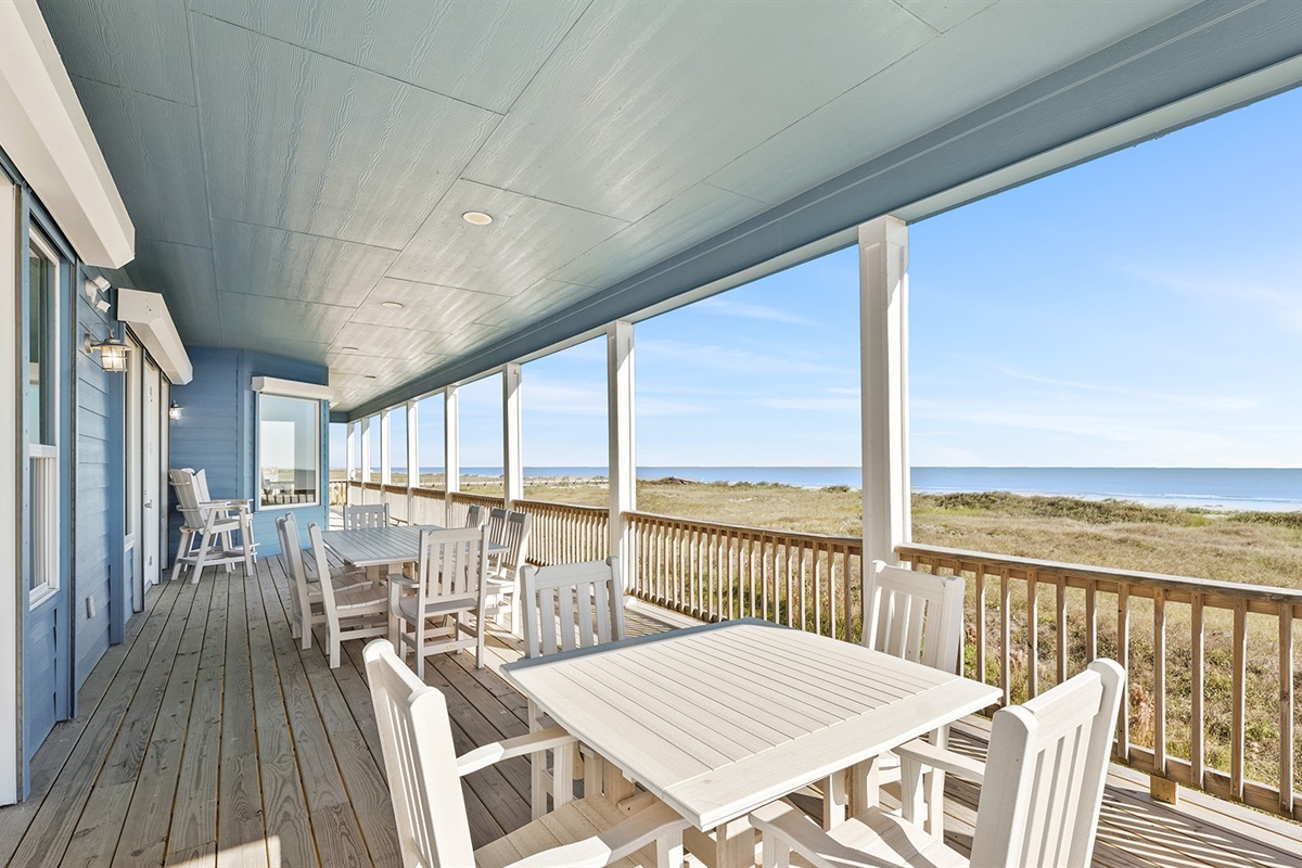 The covered deck offers shaded outdoor living space with comfortable seating and endless ocean vistas.