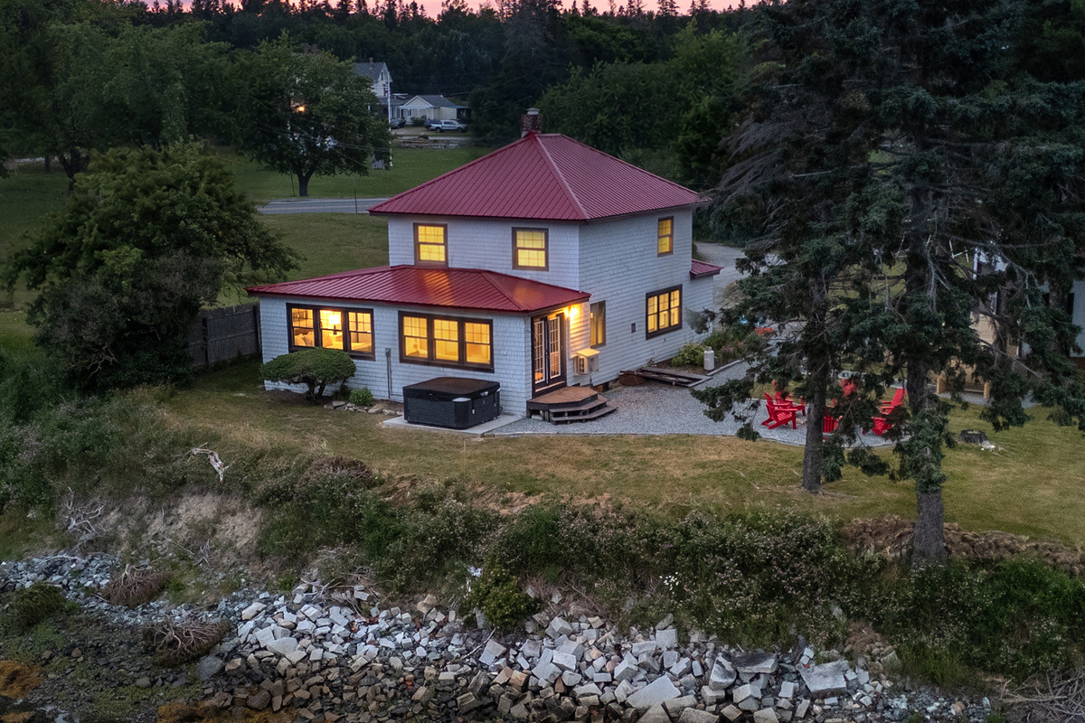 Step onto the back patio and breathe — it runs the full width of the house so everyone gets a water view at the exact same time.