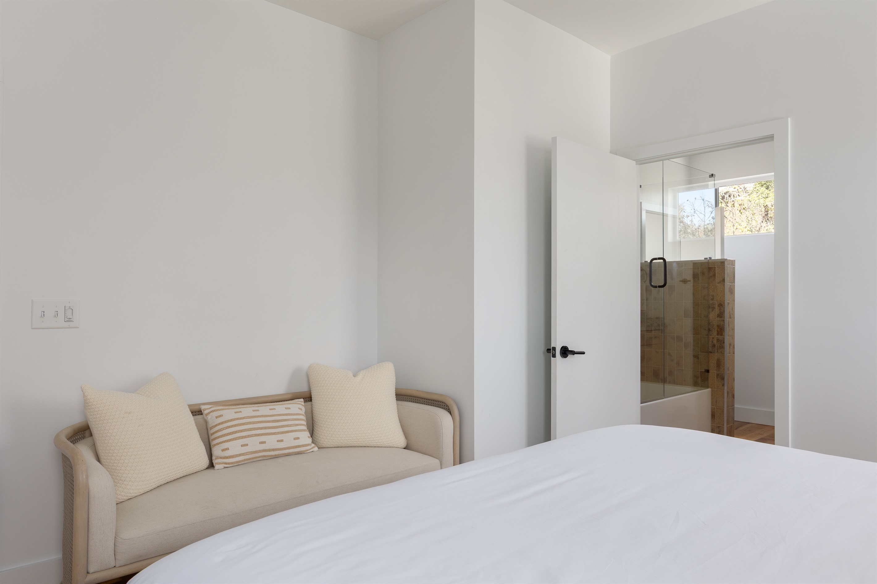 {Primary Bedroom} A bright, modern retreat with a cozy lounge seat and private ensuite bath create your calm landing spot at Gallery House.