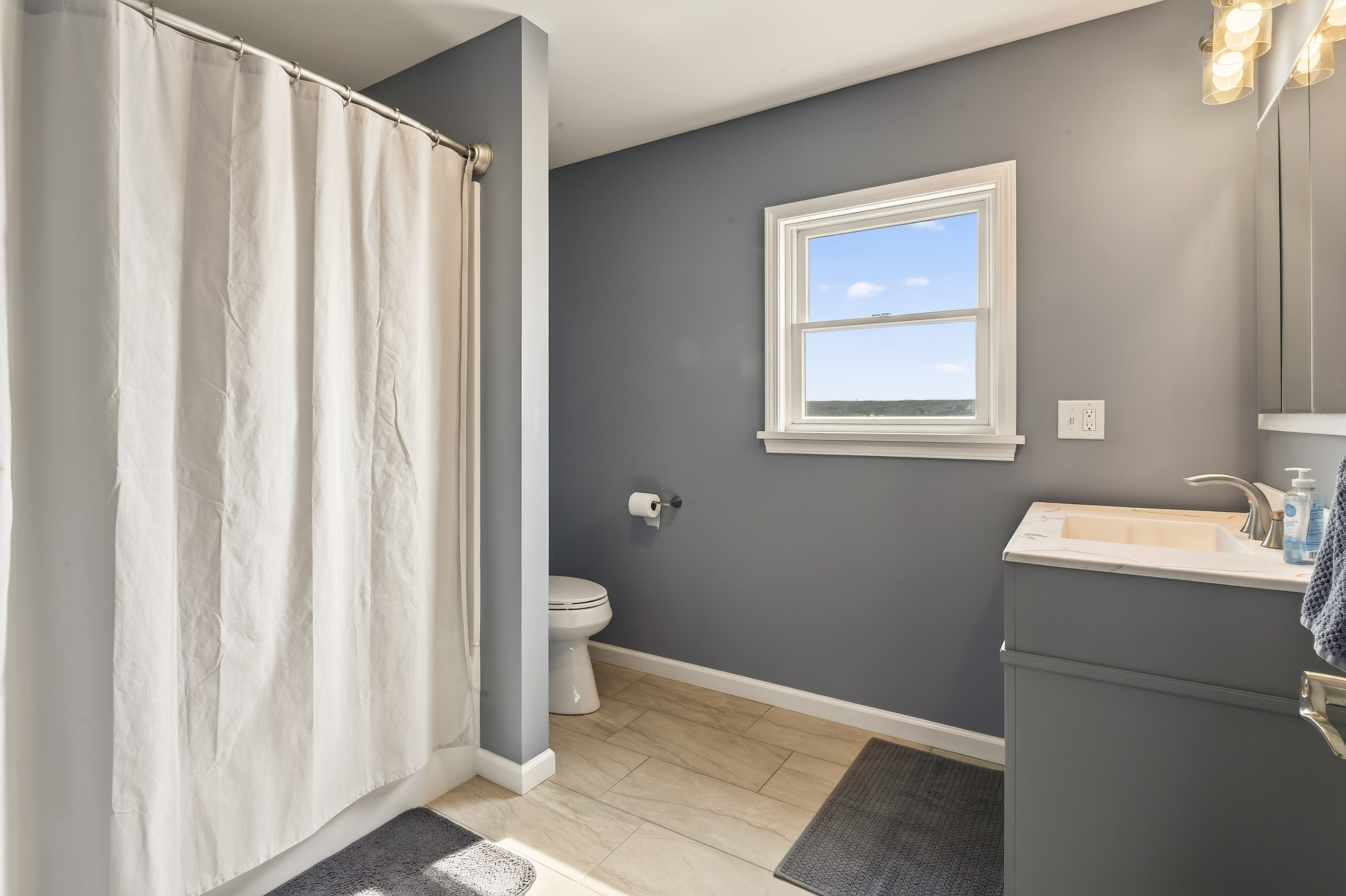 Bathroom with curtained shower and window
