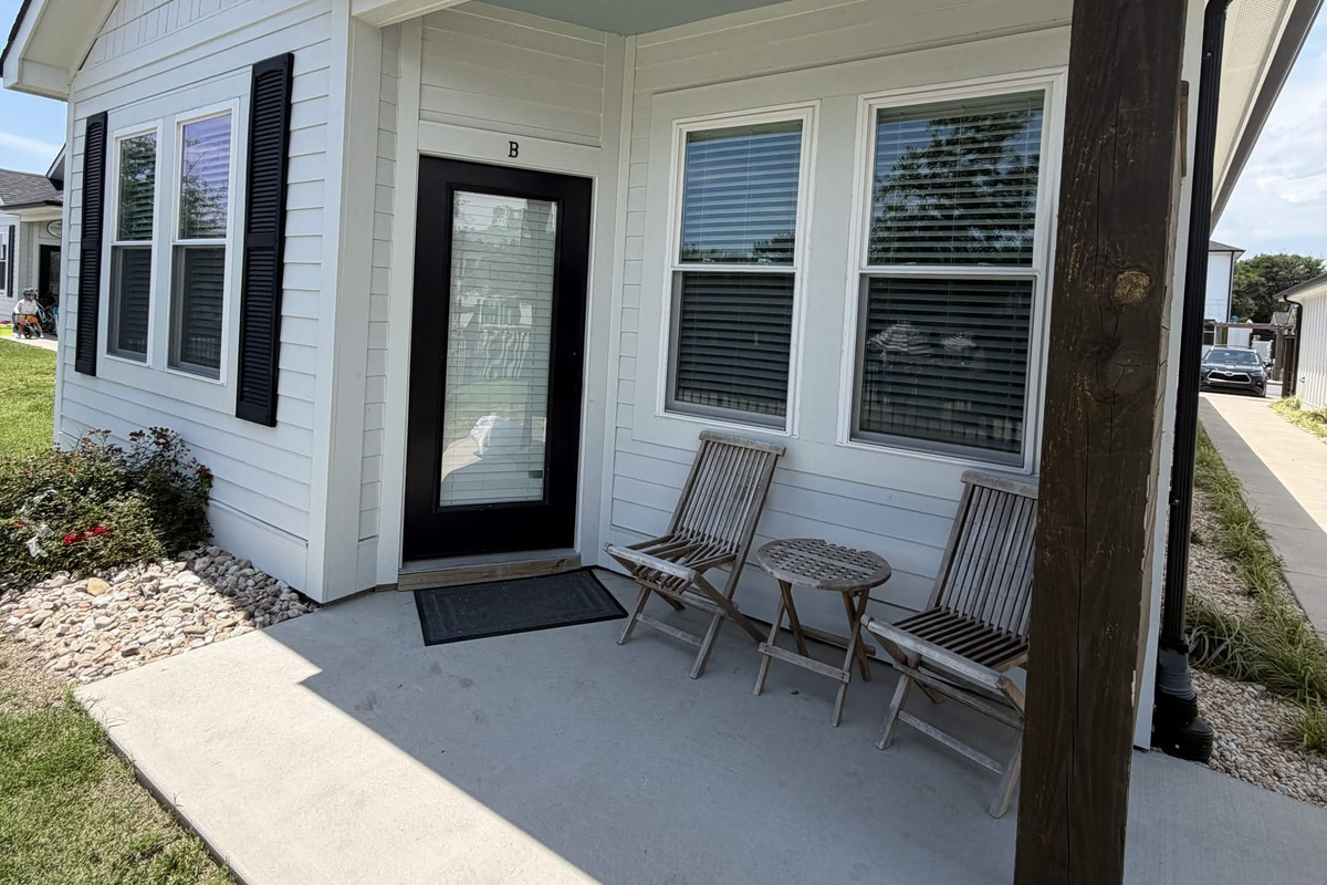 Covered front porch with comfortable seating—perfect for morning coffee or evening relaxation.