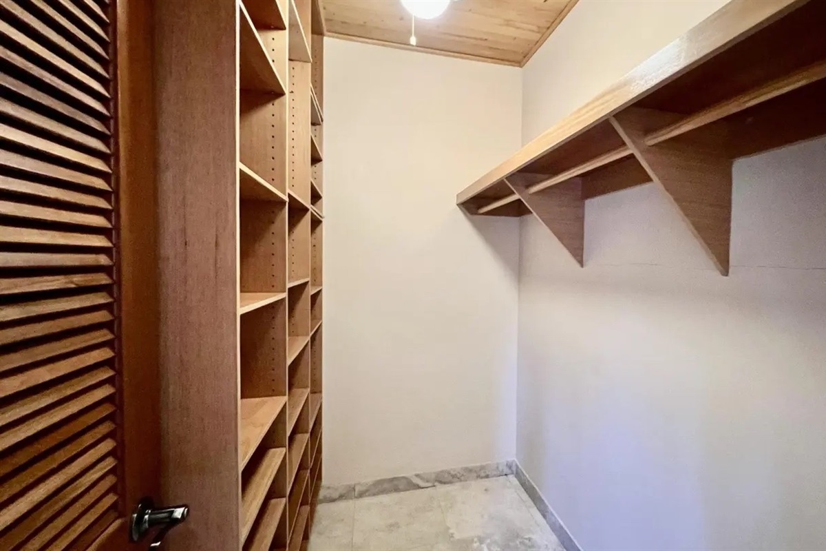 Spacious walk-in closet with built-in shelving—perfect for extended stays and unpacking.