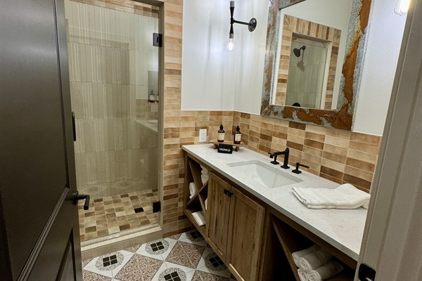 Bath #2 serves the second king bedroom &mdash; a custom wood vanity, framed Western art, and a walk-in shower all your own.