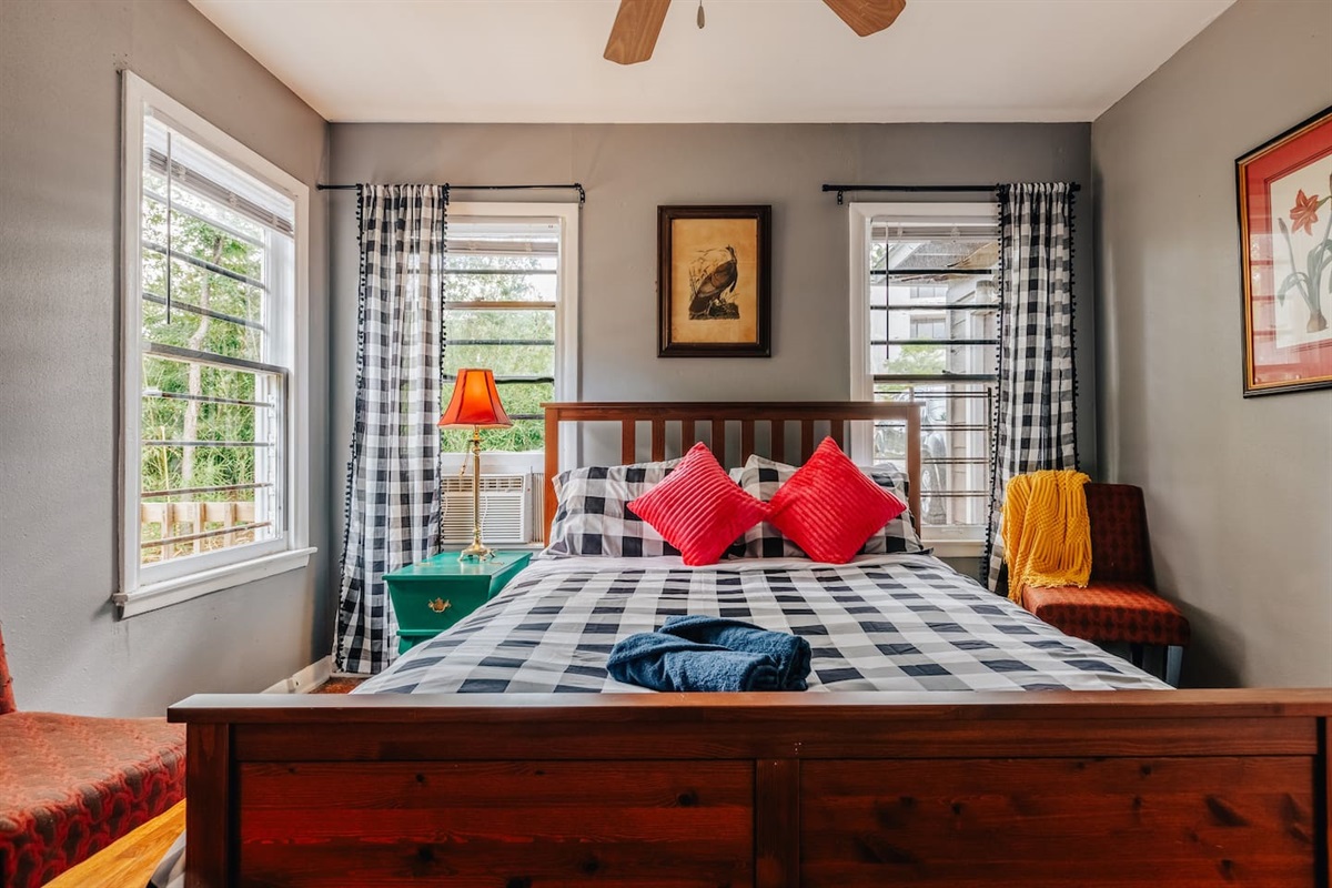 bedroom 1 with very comfortable queen bed and working desk, chairs, art.