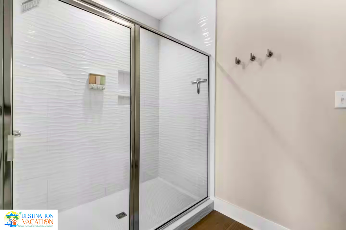 Glass-enclosed shower adds sleek coastal elegance.