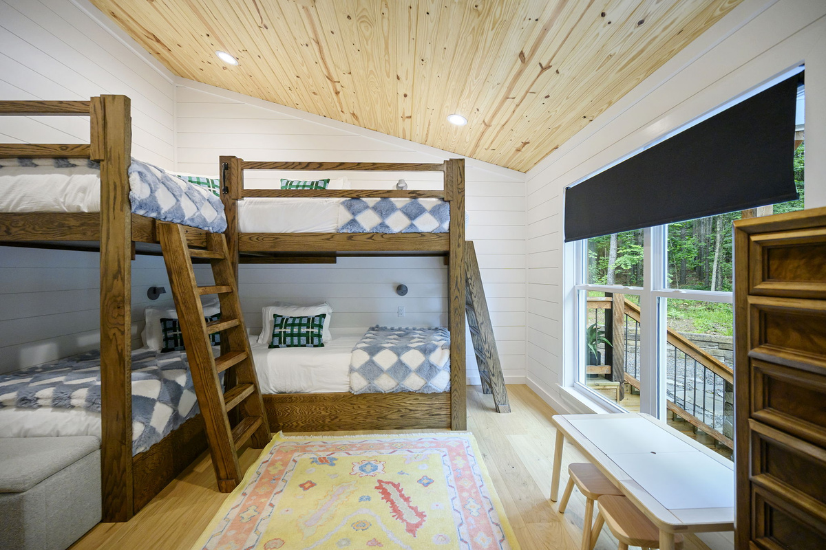 The stylish bunkroom features four twin beds, cozy designer touches, and high-end linens—creating a comfortable and welcoming retreat for kids or additional guests.
