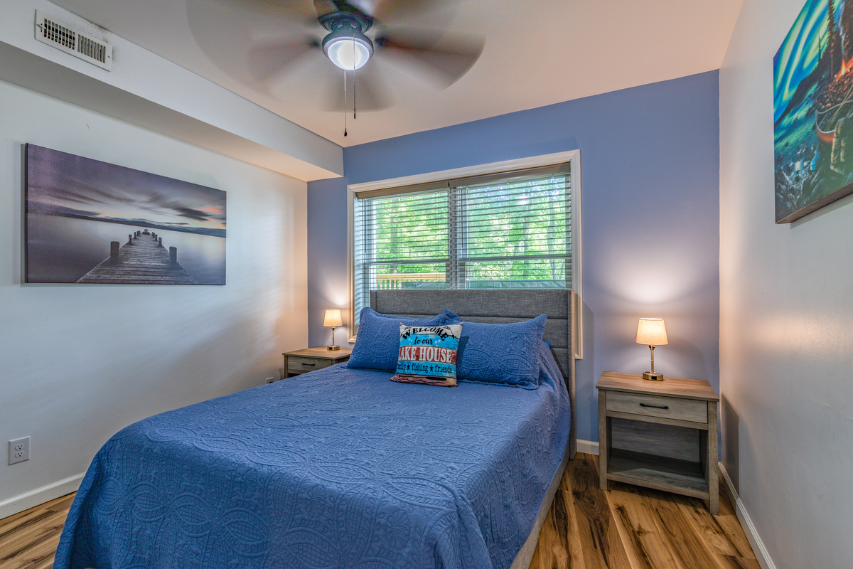 Downstairs Bedroom 4 offers a queen bed, bedside lighting, and a comfortable retreat from the gathering areas.