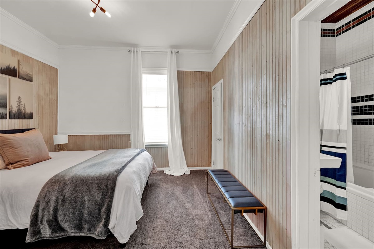 This bright second bedroom offers an en suite bath and walk-in closet — private, peaceful, and perfect for couples or teens.