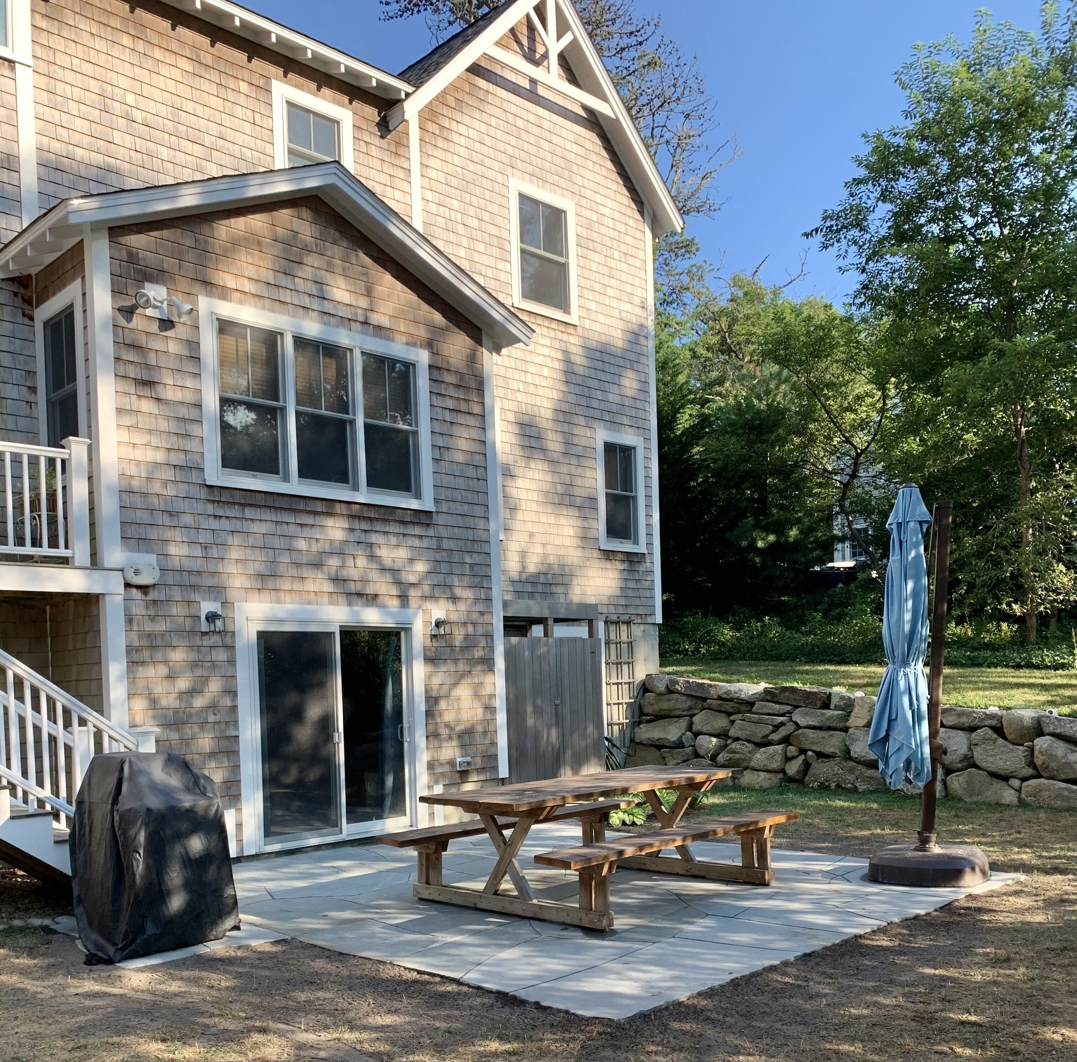 Backyard with grill, umbrella, and large picnic table. Outdoor shower. 
