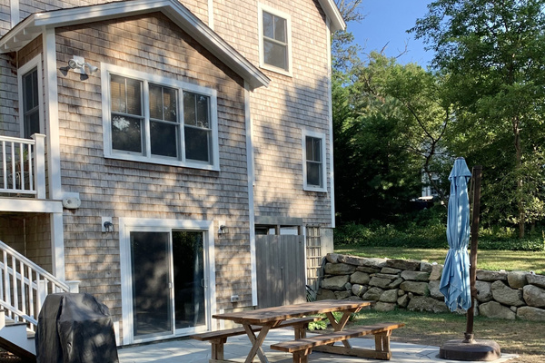 Backyard with grill, umbrella, and large picnic table. Outdoor shower. 