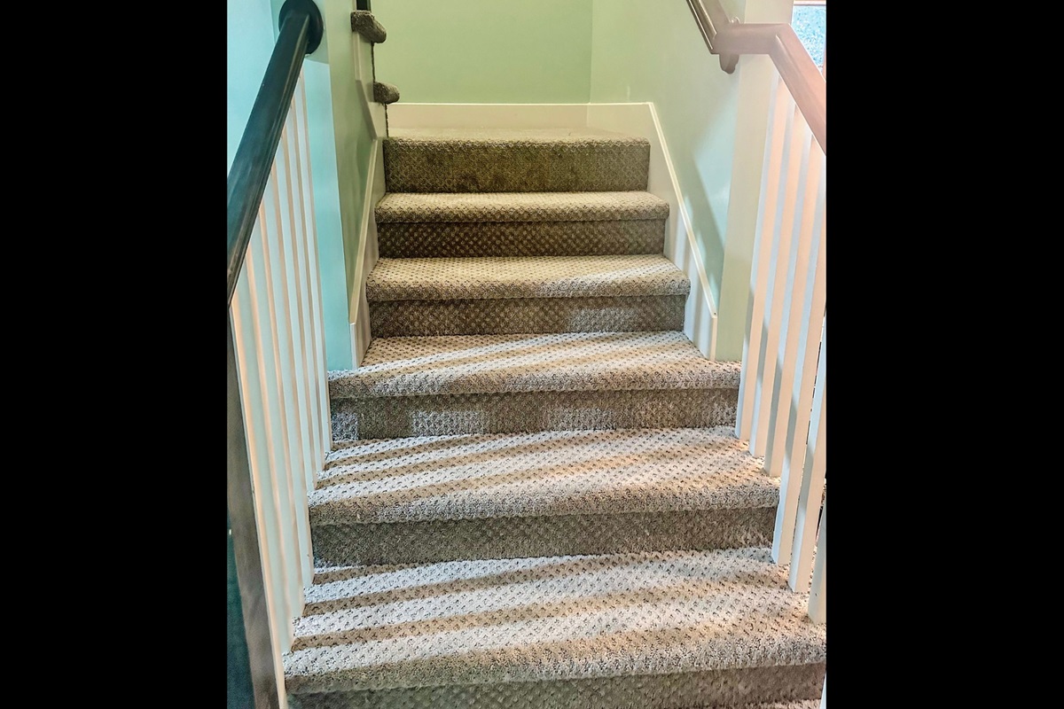 Main-level stair landing leading to the upper level bedrooms, designed for comfort and natural separation of spaces.