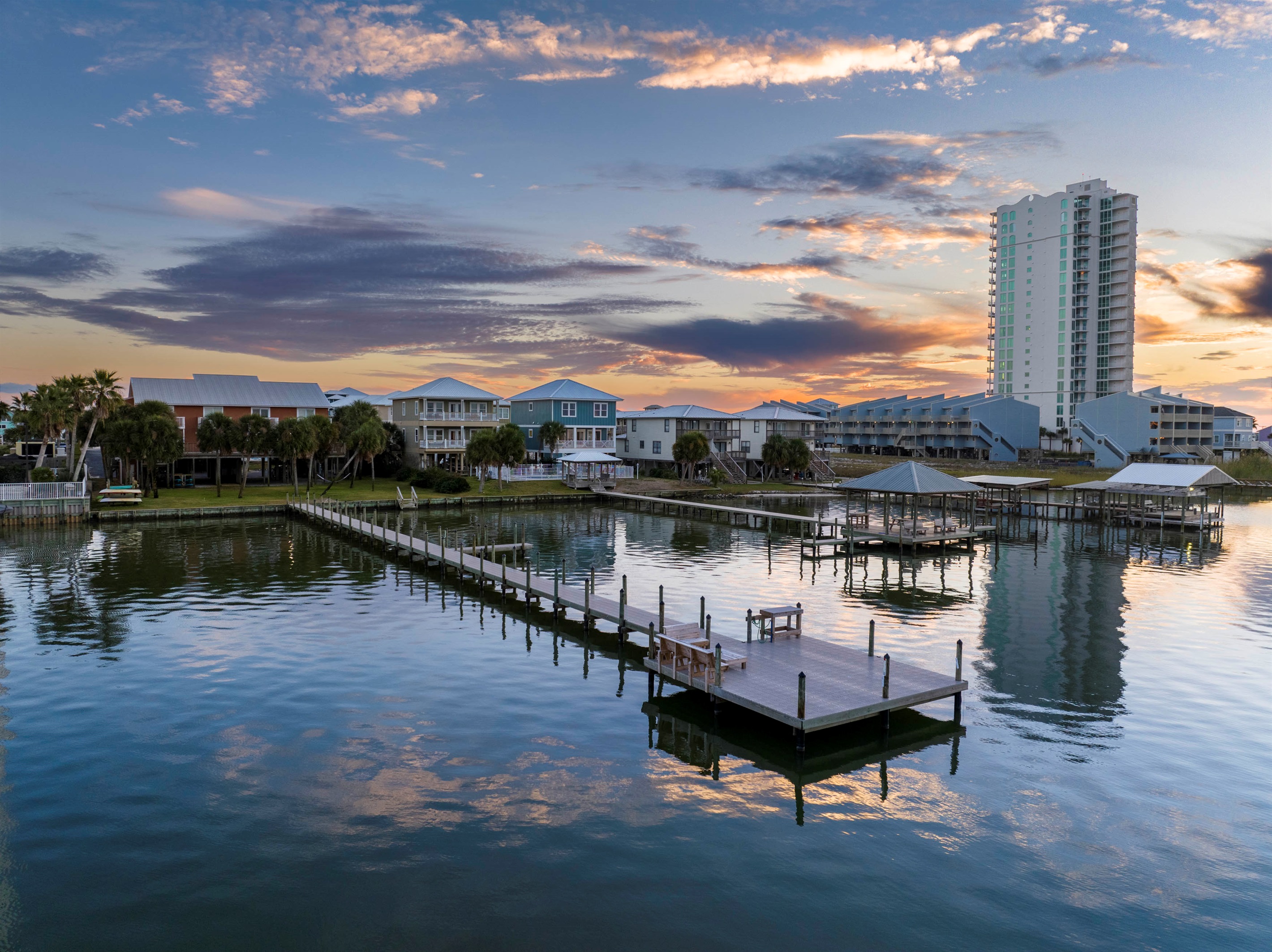 Golden hues shimmer over tranquil waters, creating a perfect, serene escape at “Bliss on the Bay” by the Laguna Bella, Gulf Shores, AL.