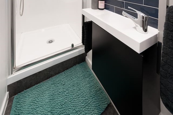 This split bathroom layout keeps the lower level easy to use, with the toilet and shower areas separated for a more practical stay.