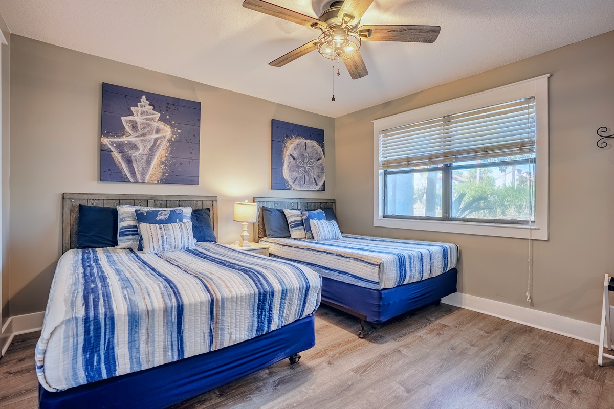 Two full beds in guest room, with ceiling fan and smart TV