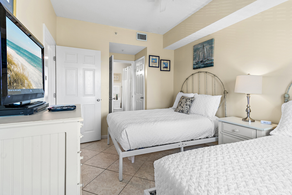 Guest Bedroom has two full beds, Smart TV, attached closet, and attached bathroom with shower/tub combo