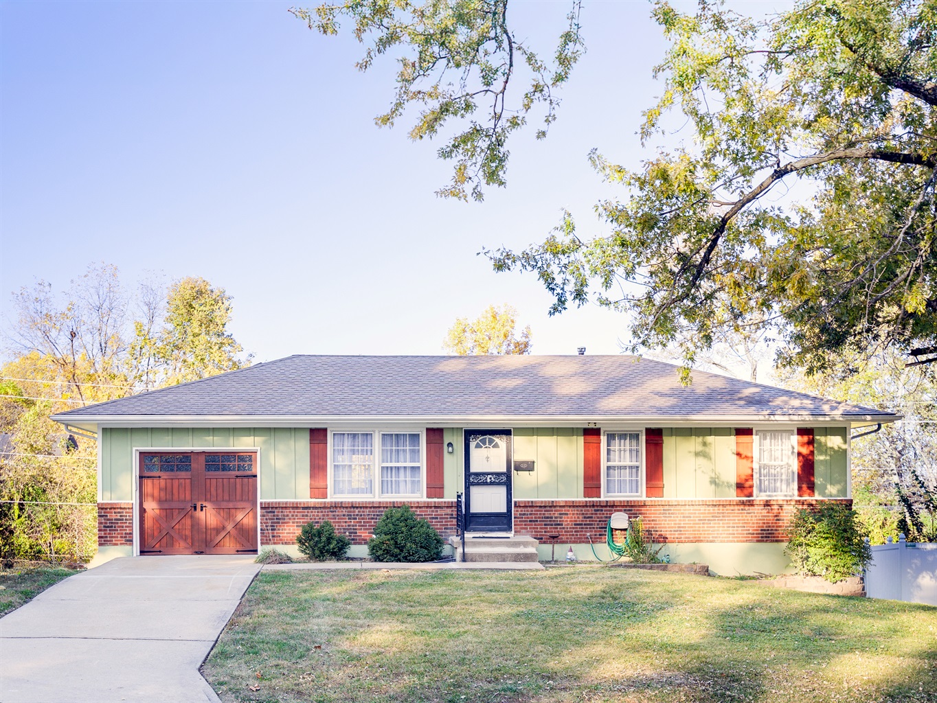 Charming street-front view with mature trees and easy curb access, offering a welcoming first impression.