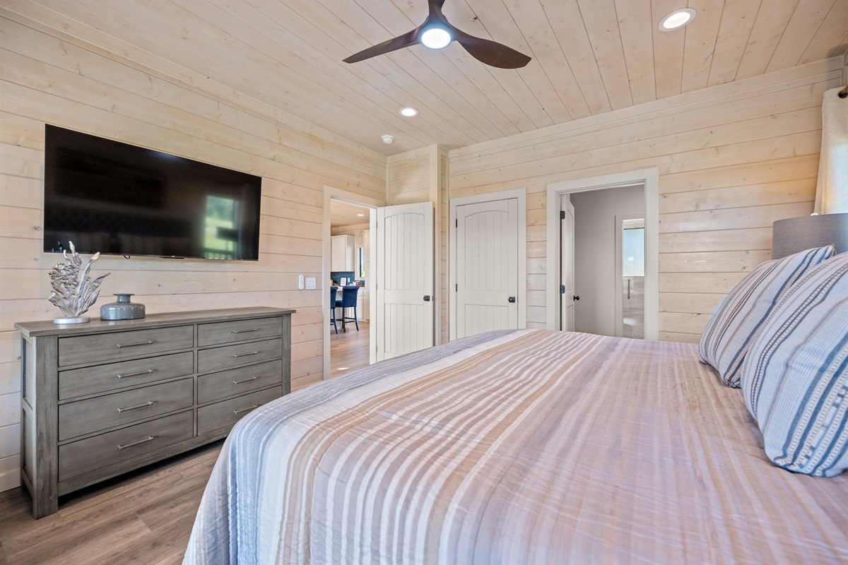 Spacious king bedroom with TV and modern farmhouse style.
