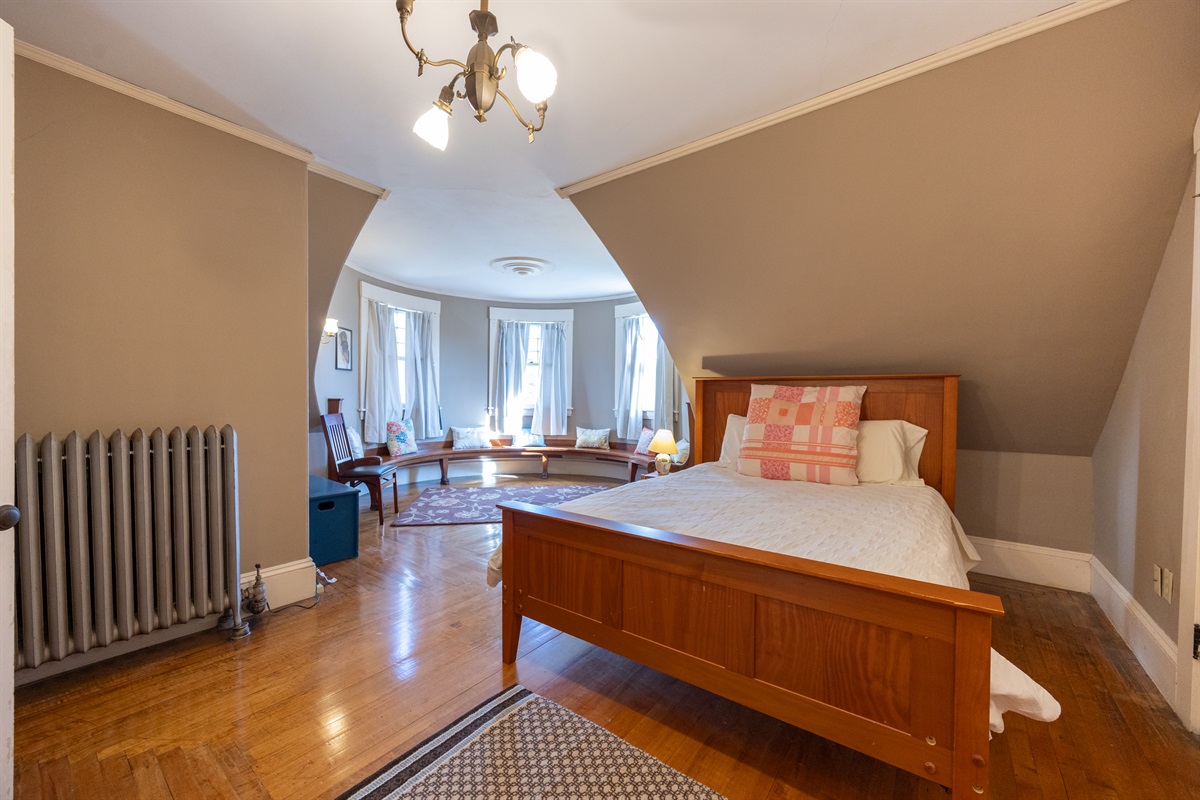 Fourth bedroom with a queen bed and a cozy spot to sit and unwind.