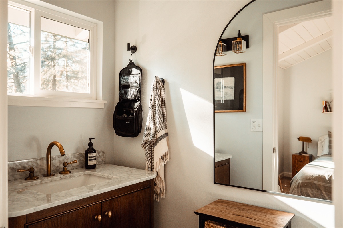 Full bathroom with a tub/shower combo — clean, elegant and designed for comfort.