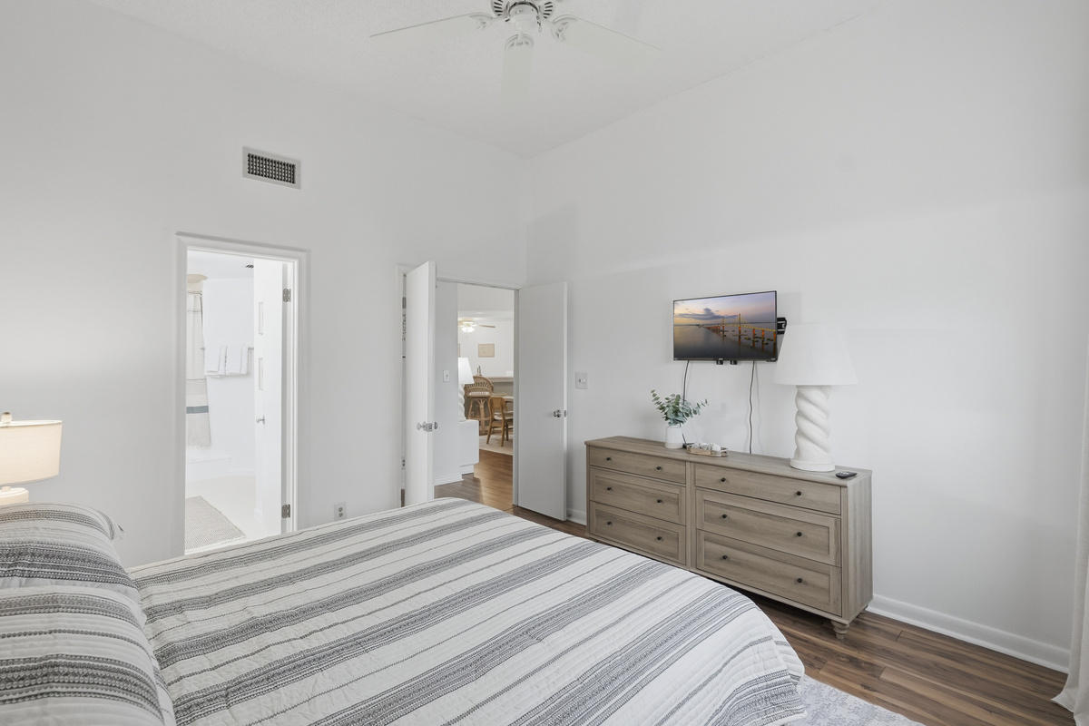 Unwind in the spacious primary bedroom, featuring a comfortable king-size bed, private ensuite bathroom, and Smart TV. After a day of soaking up the Florida sunshine, settle in, relax, and enjoy a peaceful night's rest.
