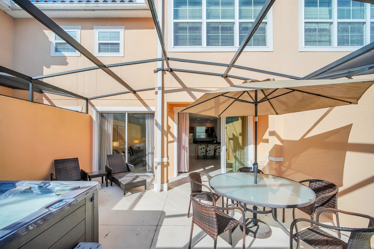 Sunny lanai with hot tub, lounge chairs and outdoor dining area.