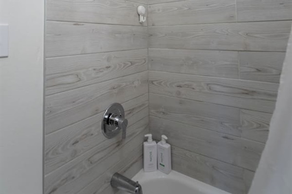 Elegant bathroom featuring both a spacious shower and a relaxing bathtub, perfect for unwinding.