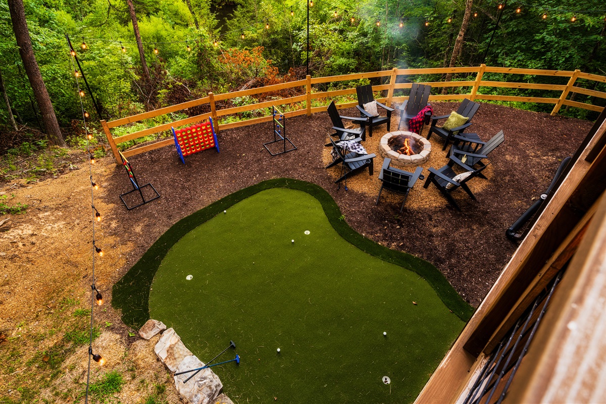 Backyard with fire pit, mini golf, string lights  and games