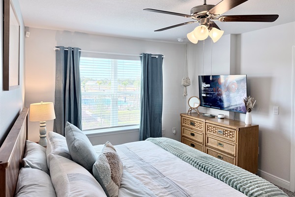 The airy primary bedroom with a great view of the recreation area