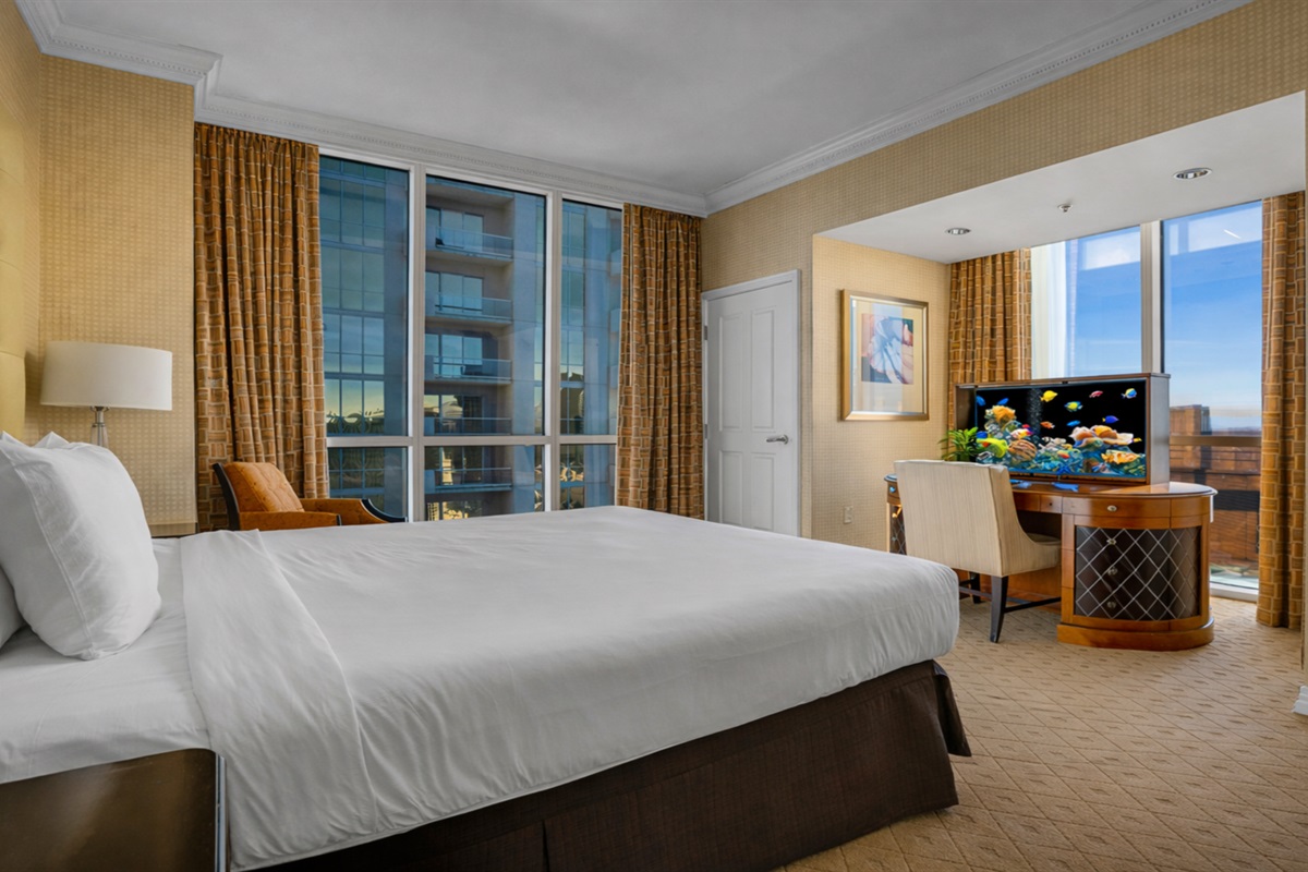 Cozy king bed with a skyline backdrop.